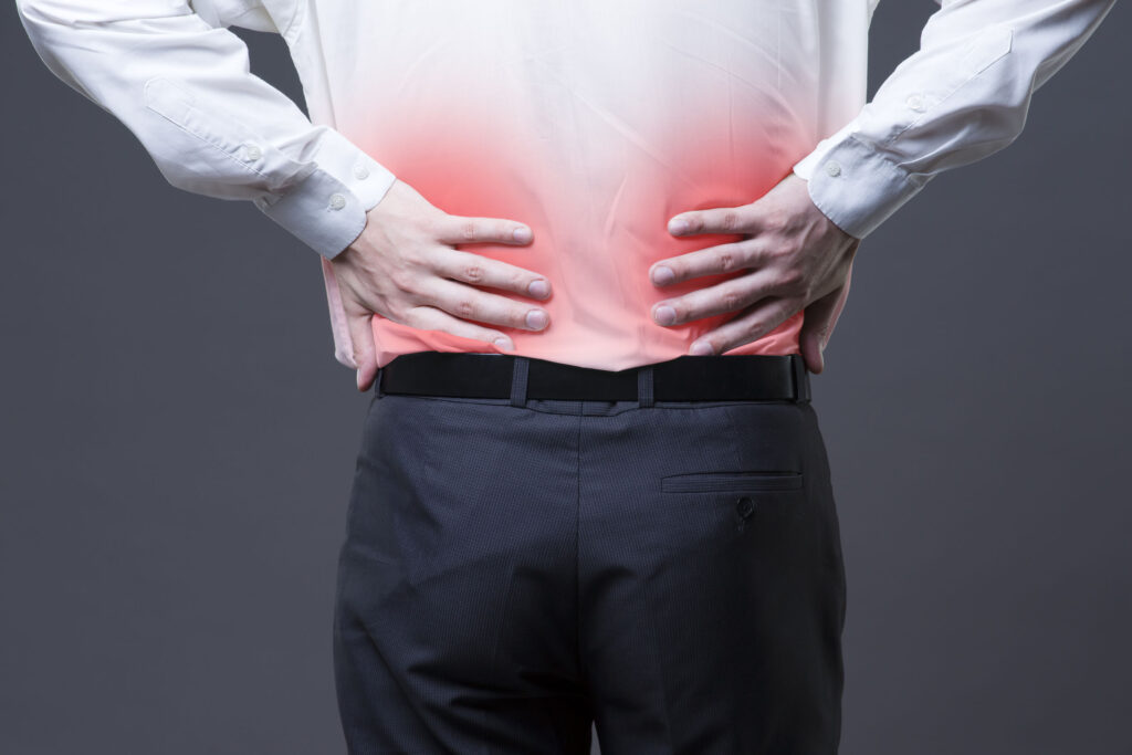 Dolor de espalda, inflamación renal, dolor en el primer plano del cuerpo del hombre sobre fondo gris con punto rojo.